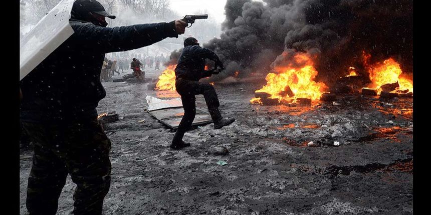 A protestor points a gun during clashes with riot police in the centre of Kiev on January 22, 2014. Ukrainian police today stormed protesters’ barricades in Kiev as violent clashes erupted and activists said that one person had been shot dead by the secur
