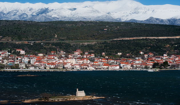 Posedarje, Zadar, 091212.Nakon sto je jucerasnji dan obiljezio snijeg, sinoc i danas je na Jadranu zapuhala olujna, ponegdje i orkanska bura sa udarima i preko 200km/h. Na fotografiji: Posedarje; u pozadini Sveto brdo pod snijegom; u prvom planu crkvica
