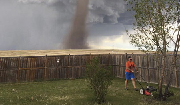 Hrabri Kanađanin kosi travu dok u pozadini bjesni tornado