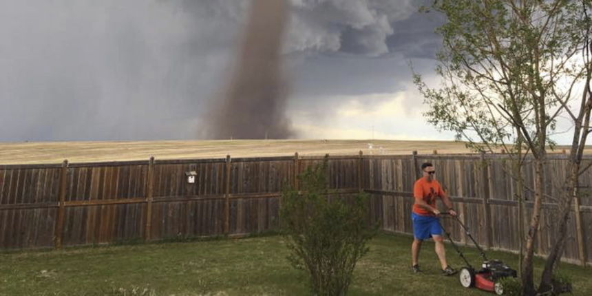 Hrabri Kanađanin kosi travu dok u pozadini bjesni tornado