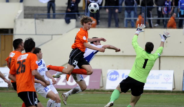 Sibenik, 160411. Stadion Subicevac Utakmica 25. kola 1.HNL izmedju NK Sibenik (narancasti) i NK Zadar (bijeli). Na slici: Niko Tokis (sib) u skoku ispred golmana Jezine (zd) Foto: Niksa Stipanicev / CROPIX