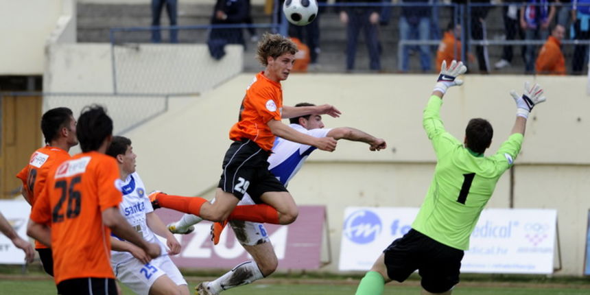Sibenik, 160411. Stadion Subicevac Utakmica 25. kola 1.HNL izmedju NK Sibenik (narancasti) i NK Zadar (bijeli). Na slici: Niko Tokis (sib) u skoku ispred golmana Jezine (zd) Foto: Niksa Stipanicev / CROPIX Sibenik, 160411. Stadion Subicevac Utakmica 25. kola 1.HNL izmedju NK Sibenik (narancasti) i NK Zadar (bijeli). Na slici: Niko Tokis (sib) u skoku ispred golmana Jezine (zd) Foto: Niksa Stipanicev / CROPIX