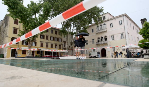Zadar, 310513.
Trg Petra Zoranica. 
Nakon svake kise, staklene plohe na novouredjenom trgu Petra Zoranica postanu skliske i opasne za setnju.
I ovog puta, reagirali su komunalni redari koji su postavili upozoravajuce trake i tako ogradili stakla. 
Foto: J