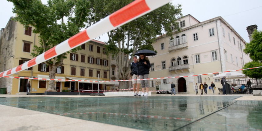 Zadar, 310513.
Trg Petra Zoranica. 
Nakon svake kise, staklene plohe na novouredjenom trgu Petra Zoranica postanu skliske i opasne za setnju.
I ovog puta, reagirali su komunalni redari koji su postavili upozoravajuce trake i tako ogradili stakla. 
Foto: J
