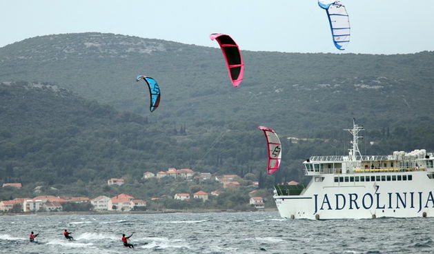 Zadar, 040410.
Na zadarskoj rivi u organizaciji kluba kluba Spinaker odrzala se prva medjunarodna kitesurfing regata, uz sudjelovanje natjecatelja iz Hrvatske, Ceske, Austrije i Slovenije. 
Na fotografiji natjecanje u zadarskom kanalu.
Foto: Vladimir Ivan