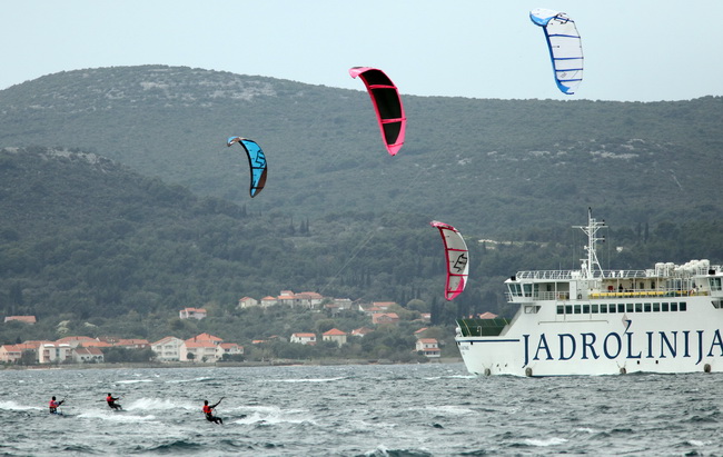 Zadar, 040410.
Na zadarskoj rivi u organizaciji kluba kluba Spinaker odrzala se prva medjunarodna kitesurfing regata, uz sudjelovanje natjecatelja iz Hrvatske, Ceske, Austrije i Slovenije. 
Na fotografiji natjecanje u zadarskom kanalu.
Foto: Vladimir Ivan