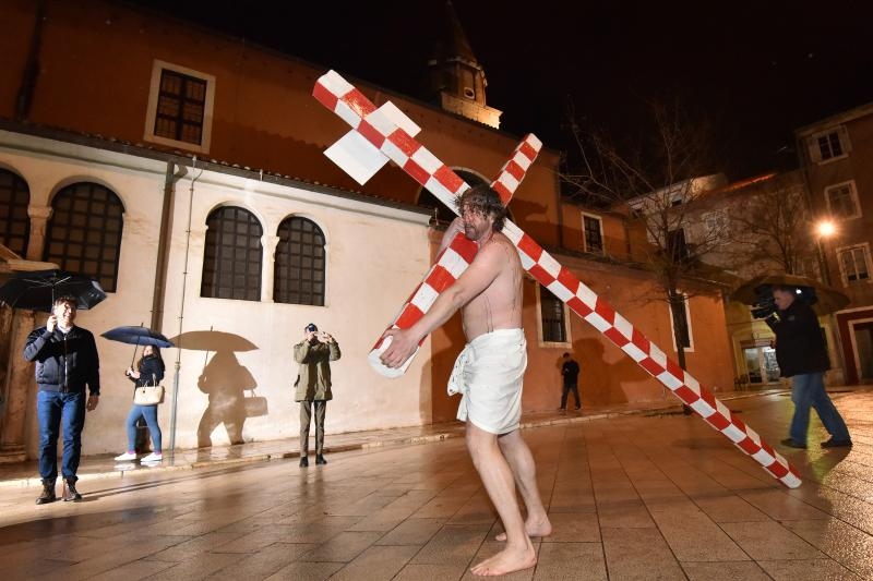 Zadarski performer Enio Mestrovic prosetao je centrom grada prerusen u Isusa noseci drveni kriz u hrvatskim detaljima. Prolazeci gradom uzvikivao je “Oprosti im Boze, ne znaju sto cine ni jedni ni drugi”. Photo: Dino Stanin/PIXSELL Zadarski performer Enio Mestrovic prosetao je centrom grada prerusen u Isusa noseci drveni kriz u hrvatskim detaljima. Prolazeci gradom uzvikivao je “Oprosti im Boze, ne znaju sto cine ni jedni ni drugi”. Photo: Dino Stanin/PIXSELL
