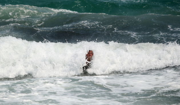 Zadar, 230712.
Orkanska bura otezava promet diljem jadranske obale. Velike guzve stvorile su se na autocesti te na prilazu paskom mostu. 
Na slici kupaci na plazi u Razancu uzivaju u valovima.
Foto: Jure Miskovic / CROPIX