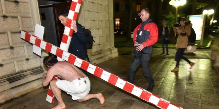 Zadarski performer Enio Mestrovic prosetao je centrom grada prerusen u Isusa noseci drveni kriz u hrvatskim detaljima. Prolazeci gradom uzvikivao je “Oprosti im Boze, ne znaju sto cine ni jedni ni drugi”. Photo: Dino Stanin/PIXSELL Zadarski performer Enio Mestrovic prosetao je centrom grada prerusen u Isusa noseci drveni kriz u hrvatskim detaljima. Prolazeci gradom uzvikivao je “Oprosti im Boze, ne znaju sto cine ni jedni ni drugi”. Photo: Dino Stanin/PIXSELL