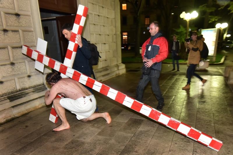 Zadarski performer Enio Mestrovic prosetao je centrom grada prerusen u Isusa noseci drveni kriz u hrvatskim detaljima. Prolazeci gradom uzvikivao je “Oprosti im Boze, ne znaju sto cine ni jedni ni drugi”. Photo: Dino Stanin/PIXSELL Zadarski performer Enio Mestrovic prosetao je centrom grada prerusen u Isusa noseci drveni kriz u hrvatskim detaljima. Prolazeci gradom uzvikivao je “Oprosti im Boze, ne znaju sto cine ni jedni ni drugi”. Photo: Dino Stanin/PIXSELL