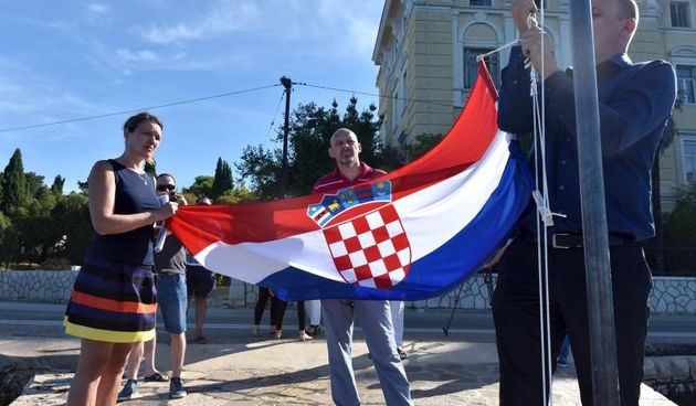 Marjana Botić, Marko Pupić-Bakrač i Ante Rubeša dižu hrvatsku zastavu na mulu kod ulaza u Maraska park. Photo. Dino Stanin/PIXSELL