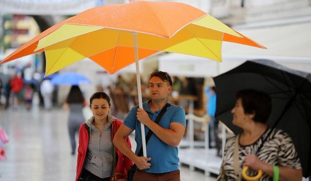 Kisni dan u centru grada nije omeo turiste u setnji i razgledavanju. Photo: Filip Brala/PIXSELL