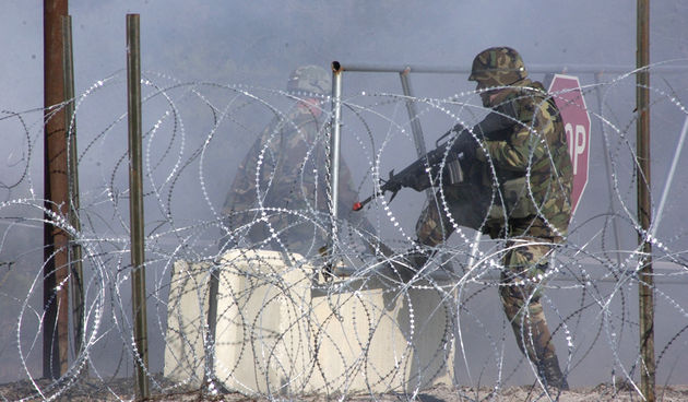 A security guard closed the gate after the locals attacked the base camp to gain access during the FOB exercise.

Photo by
SSG A. H. Scott