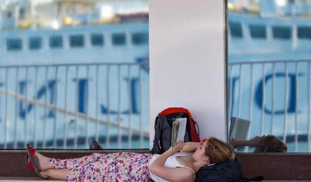 U jutarnjim satima prvog turistickog vikenda u srpnju u Trajektnoj luci Split nisu se stvarale velike guzve. Djevojka cita knjigu dok ceka na ukrcaj. Photo: Davor Puklavec/PIXSELL