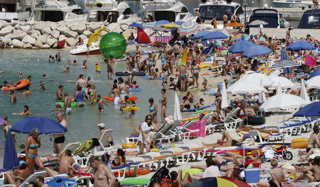 Makarska, 030711.
Prvi srpanjski vikend i prave ljetne vrucine doveli su veliki broj turista na Makarsku rivijeru. Plaze su prepune kupaca koji uzivaju u suncanju i kupanju. 
Na slici: Kupaci.
Foto: Ivo Ravlic / CROPIX