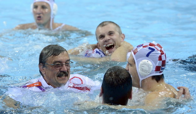 London, 120812.
Vaterpolo Arena.
Hrvatska muska vaterpolo reprezentacija igra finalnu utakmicu protiv Italije tijekom Olimpijskih Igara u Londonu.
Na fotografiji: Hrvatska je osvojila zlatnu medalju, izbornik Ratko Rudic u bazenu sa igracima.
Foto: Drago