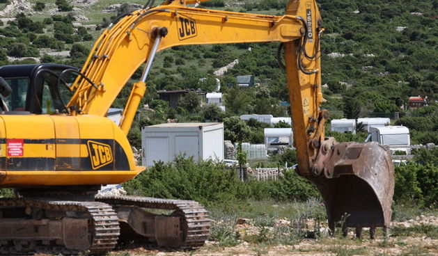 Zadar, 140510.
Drugi dan akcije uklanjanja bespravno izgradjenih objekata na  predjelu Krizine kod Kolana na otoku Pagu neki su vlasnici su sami uklanjli objekte.
Na fotografiji : bager nije imao posla.
Foto: Vladimir Ivanov / CROPIX