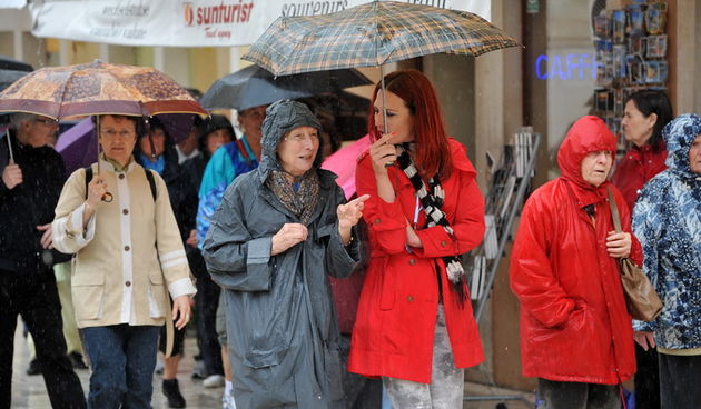 Zadar, 160513.
Pad tepmerature od 10 stupnjeva u odnosu na jucerasnji dan i kisa koja je padala uz jak juzni vjetar, natjerali su turiste da grad danas razgledavaju u kisnim kabanicama.
Na fotografiji: turisti.
Foto: Luka Gerlanc / CROPIX