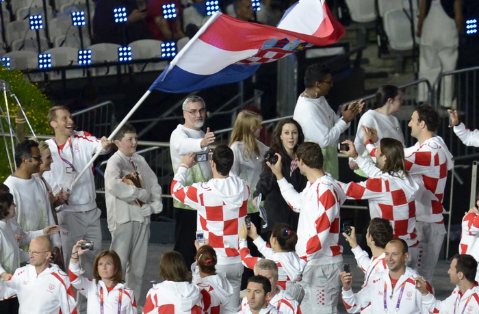 London, 270712.
Olimpijski stadion.
Svecano otvaranje Olimpijskih Igra u Londonu.
Na fotografiji: hrvatski sportasi u defileu, rukometni golman Venio Losert nosi zastavu dok ga slikaju njegove kolege iz reprezentacije.
Foto: Drago Sopta / CROPIX