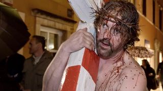 Zadarski performer Enio Mestrovic prosetao je centrom grada prerusen u Isusa noseci drveni kriz u hrvatskim detaljima. Prolazeci gradom uzvikivao je “Oprosti im Boze, ne znaju sto cine ni jedni ni drugi”. Photo: Dino Stanin/PIXSELL Zadarski performer Enio Mestrovic prosetao je centrom grada prerusen u Isusa noseci drveni kriz u hrvatskim detaljima. Prolazeci gradom uzvikivao je “Oprosti im Boze, ne znaju sto cine ni jedni ni drugi”. Photo: Dino Stanin/PIXSELL