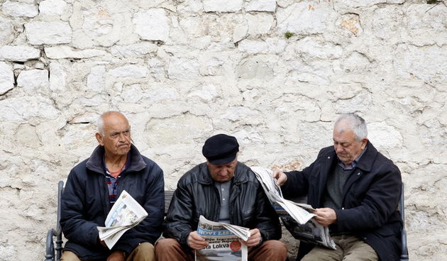 Zadar, 130312.Dnevni ritual citanja novina trojice umirovljenika na Poluotoku pod zidom samostana Sv Frane.Foto: Jure Miskovic / CROPIX