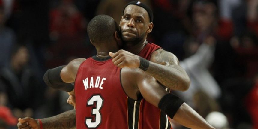 LeBron James (R) is congratulated by teammate Dwyane Wade // Reuters