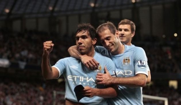 Manchester City’s Carlos Tevez, left, celebrates with teammates after scoring his second goal  // AP Photo