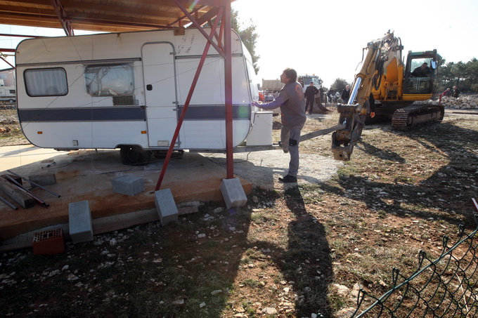 Vir, 190213.
Otok Vir. 
Kao sto je i najavljeno, pocelo je rusenje ilegalnih objekata. Polazisna tocka bagera je otok Vir na kojem je oko 8.000 bespravno izgradjenih objekata. Nesto prije 9 sati prvi je bager stigao na taj otok. Policija asistira na podru