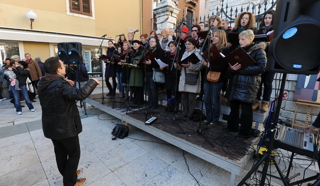 Zadar, 221212.
Predblagdansko subotnje jutro na zadarskom Poluotoku bilo je bogato raznim dogadjanjima. U isto vrijeme su zadarski zborovi, limena glazba i pojedini pjevaci udruzili snage te izvodili Bozicne pjesme.
Na fotografiji: zbor Petar Zoranic.
Fot