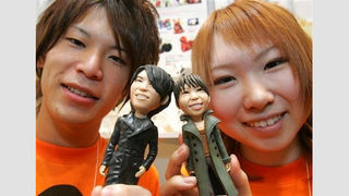 Hideaki Suzuki, left, and Eri Nagase, both employees of toy maker Grand Chariot display their look-alike figures at the International Gift Show in Tokyo Wednesday, Sept. 5, 2007. From one photograph of an individual, the maker produces a look-alike figure