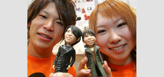 Hideaki Suzuki, left, and Eri Nagase, both employees of toy maker Grand Chariot display their look-alike figures at the International Gift Show in Tokyo Wednesday, Sept. 5, 2007. From one photograph of an individual, the maker produces a look-alike figure