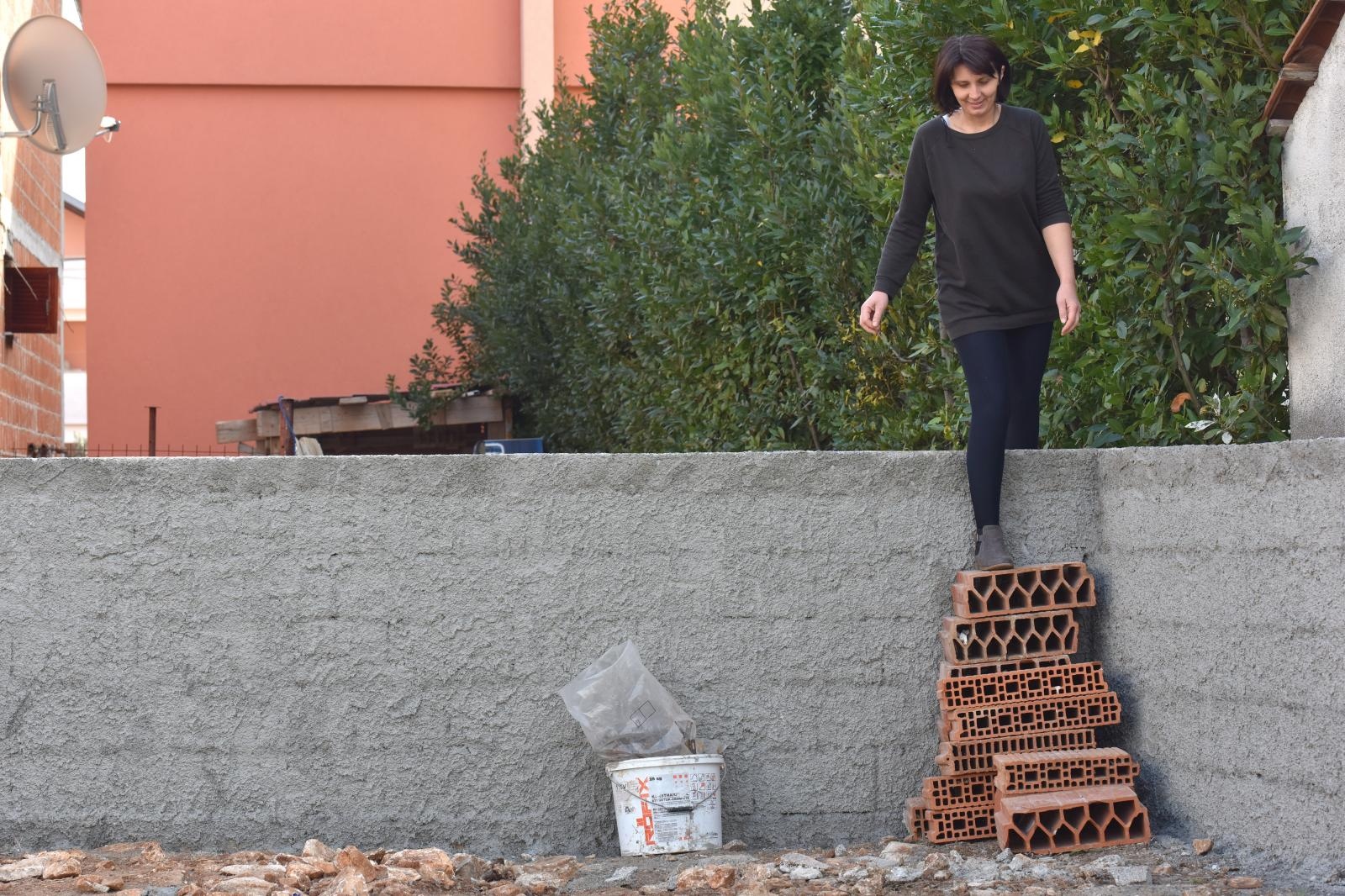 Merica Miškovic mora preskakati ogradni zid kako bi došla do svoje kuće