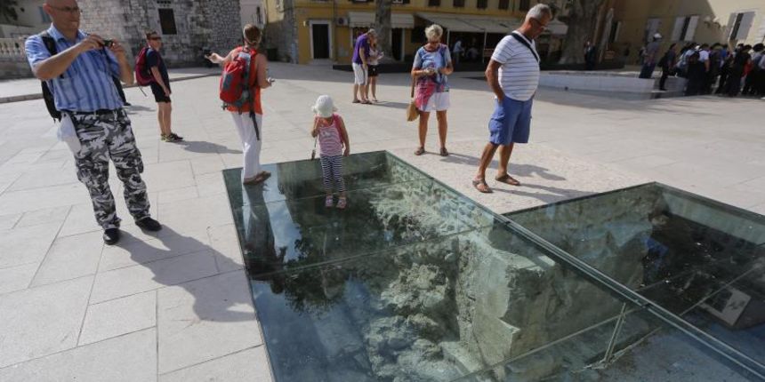 26.09.2013., Zadar – Turisti bacaju novac u nadi da ce im donijeti srecu, pa se tako ispod plesiglasa na Trgu Petra Zoranica moze naci i novcanica od 200 kuna. Staklo jos nitko nije pokusao razbiti, ali sudeci po brzini kojom se novac skuplja netko bi m