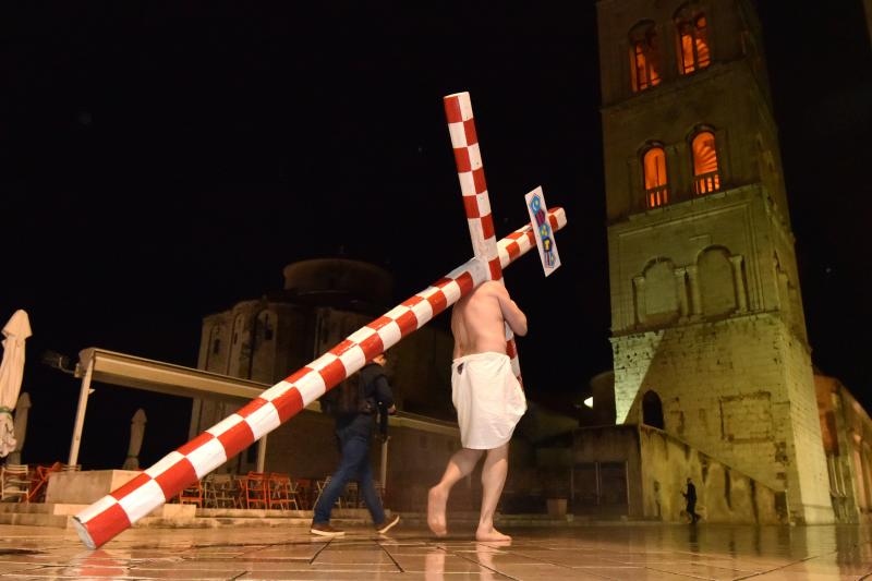 Zadarski performer Enio Mestrovic prosetao je centrom grada prerusen u Isusa noseci drveni kriz u hrvatskim detaljima. Prolazeci gradom uzvikivao je “Oprosti im Boze, ne znaju sto cine ni jedni ni drugi”. Photo: Dino Stanin/PIXSELL Zadarski performer Enio Mestrovic prosetao je centrom grada prerusen u Isusa noseci drveni kriz u hrvatskim detaljima. Prolazeci gradom uzvikivao je “Oprosti im Boze, ne znaju sto cine ni jedni ni drugi”. Photo: Dino Stanin/PIXSELL