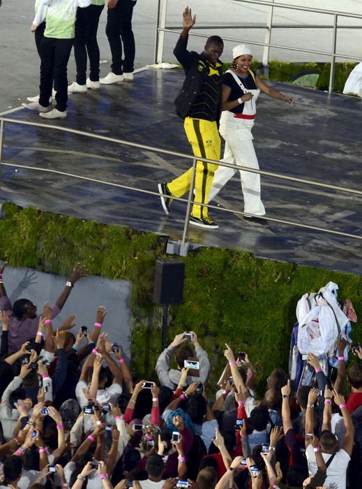London, 270712.
Olimpijski stadion.
Svecano otvaranje Olimpijskih Igra u Londonu.
Na fotografiji: Usain Bolt nabrzi atleticar na svijetu nosio zastavu za Jamajku pozdravlja publiku.
Foto: Drago Sopta / CROPIX