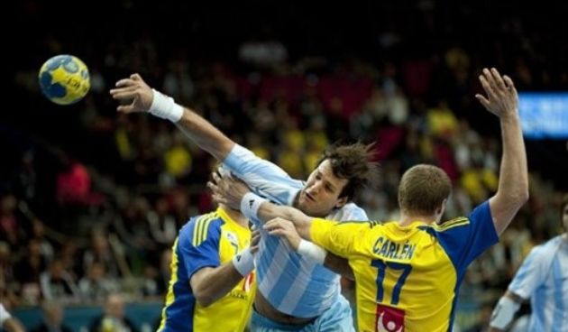 Gonzalo Carou, centre, of Argentina scores during the men’s World Handball Championships group D match between Sweden and Argentina // AP Photo