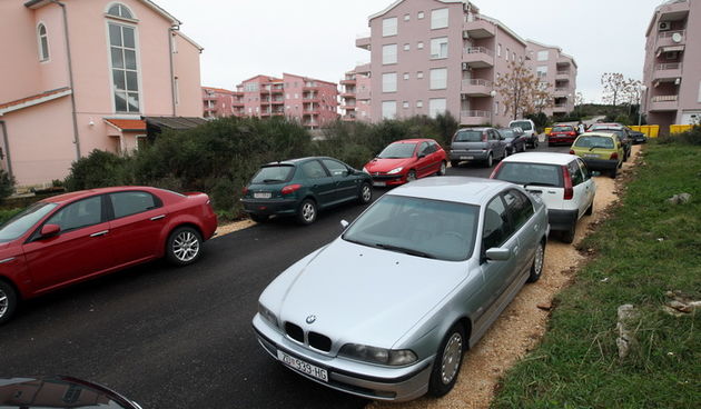 Zadar, 130213.
Stanari tzv. galicevih zgrada u Diklu, unatoc najavi bojkota novog prilaznog puta koriste isti kao parkiraliste.
Na slici put i parkirani automobili stanara galicevih zgrada.
Foto: Jure Miskovic / CROPIX