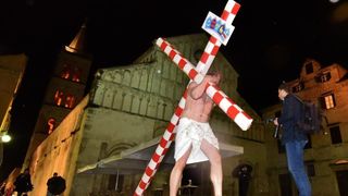 Zadarski performer Enio Mestrovic prosetao je centrom grada prerusen u Isusa noseci drveni kriz u hrvatskim detaljima. Prolazeci gradom uzvikivao je “Oprosti im Boze, ne znaju sto cine ni jedni ni drugi”. Photo: Dino Stanin/PIXSELL Zadarski performer Enio Mestrovic prosetao je centrom grada prerusen u Isusa noseci drveni kriz u hrvatskim detaljima. Prolazeci gradom uzvikivao je “Oprosti im Boze, ne znaju sto cine ni jedni ni drugi”. Photo: Dino Stanin/PIXSELL