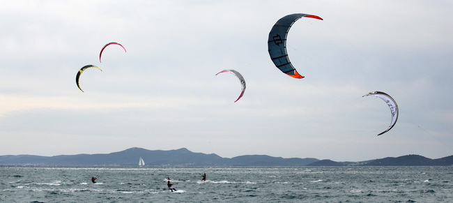 Zadar, 040410.
Na zadarskoj rivi u organizaciji kluba kluba Spinaker odrzala se prva medjunarodna kitesurfing regata, uz sudjelovanje natjecatelja iz Hrvatske, Ceske, Austrije i Slovenije. 
Na fotografiji natjecanje u zadarskom kanalu.
Foto: Vladimir Ivan